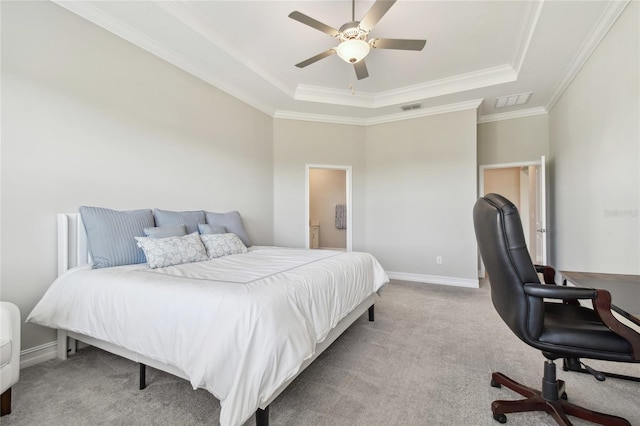 carpeted bedroom with a tray ceiling, ceiling fan, and crown molding