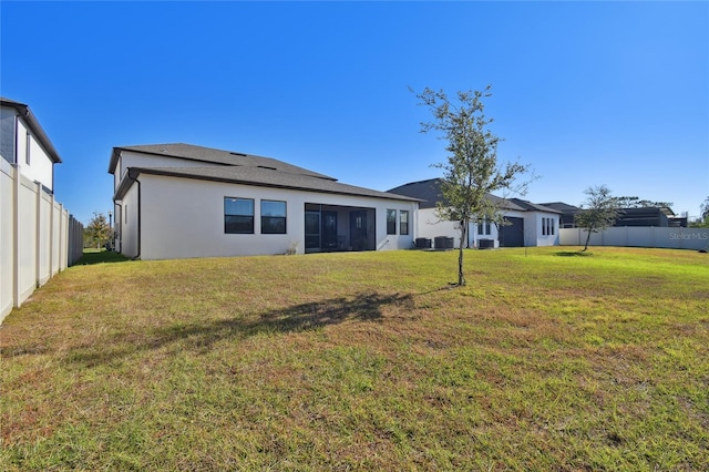 rear view of house featuring a lawn, a sunroom, and cooling unit