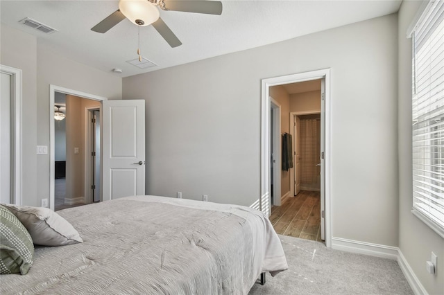 bedroom with multiple windows, light carpet, and ceiling fan