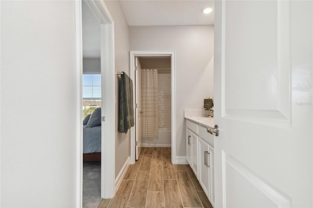 bathroom with hardwood / wood-style flooring, vanity, and curtained shower