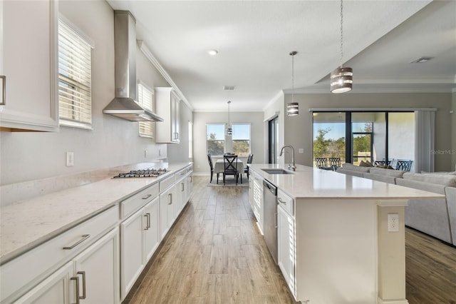 21291 Snowy Orchid Ter, Land O Lakes, FL 34637 - kitchen featuring wall chimney exhaust hood, appliances with stainless steel finishes, light wood-type flooring, crown molding, and a sink