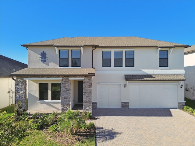 21291 Snowy Orchid Ter, Land O Lakes, FL 34637 - view of front of property featuring stucco siding, a garage, stone siding, decorative driveway, and a shingled roof