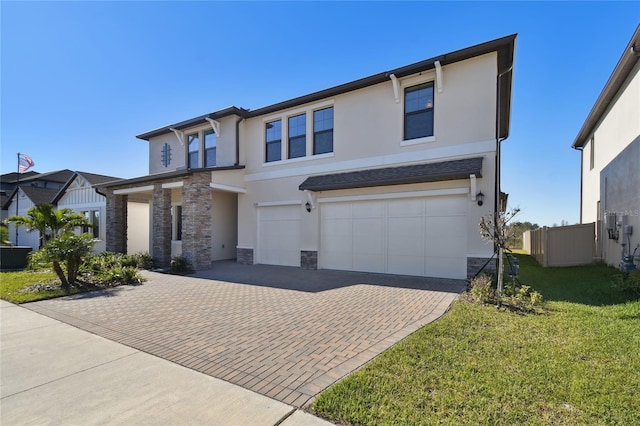 21291 Snowy Orchid Ter, Land O Lakes, FL 34637 - view of front of home with stone siding, stucco siding, an attached garage, and decorative driveway