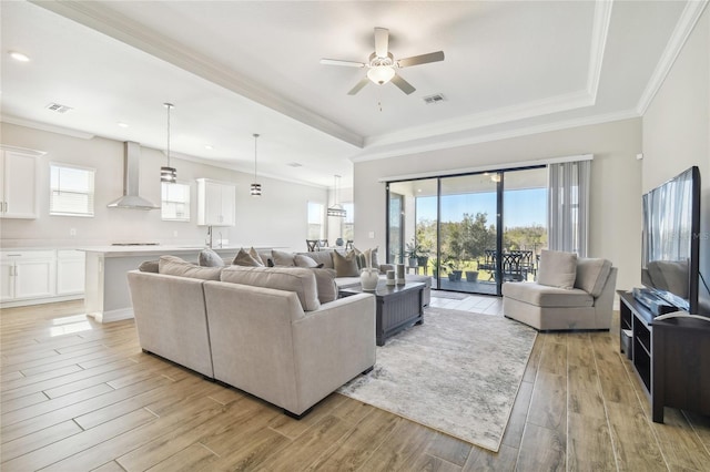 21291 Snowy Orchid Ter, Land O Lakes, FL 34637 - living area featuring a ceiling fan, a raised ceiling, light wood-type flooring, ornamental molding, and recessed lighting