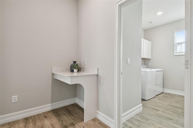 21291 Snowy Orchid Ter, Land O Lakes, FL 34637 - washroom with cabinet space, washing machine and dryer, light wood finished floors, and baseboards