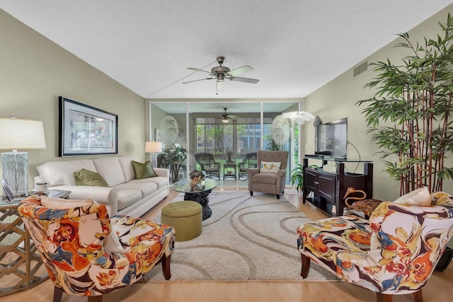 living room featuring a textured ceiling, light hardwood / wood-style floors, and ceiling fan