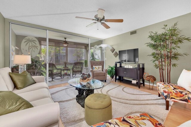 living room with ceiling fan, light hardwood / wood-style flooring, and lofted ceiling