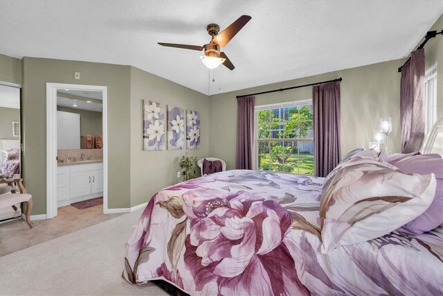 bedroom with ceiling fan, light tile patterned flooring, and ensuite bathroom