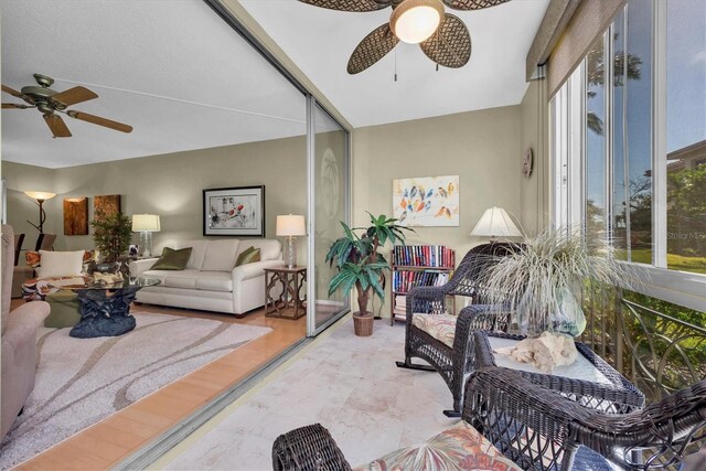 living room with ceiling fan and light hardwood / wood-style flooring