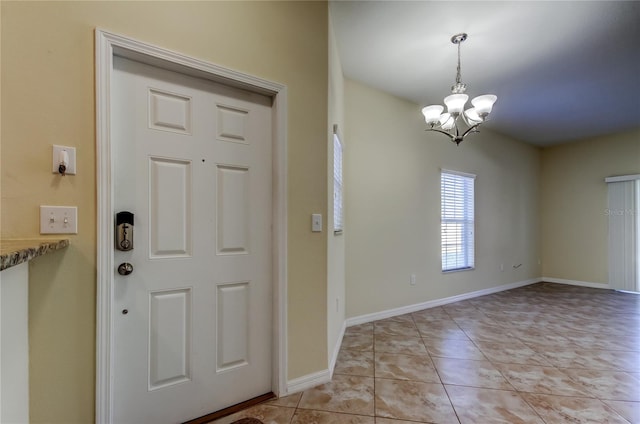 entryway featuring light tile patterned floors and a chandelier