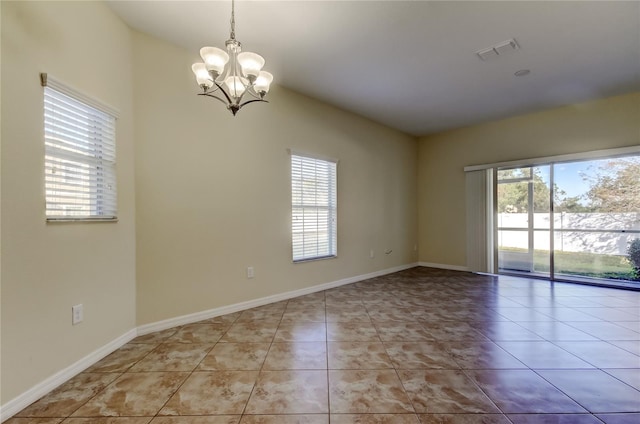 unfurnished room featuring a notable chandelier, a healthy amount of sunlight, and light tile patterned floors