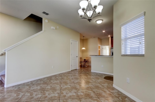 unfurnished living room with light tile patterned floors and an inviting chandelier