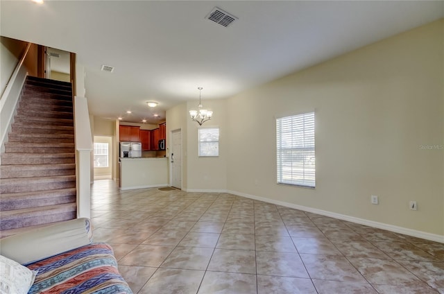 unfurnished living room featuring light tile patterned floors and a notable chandelier