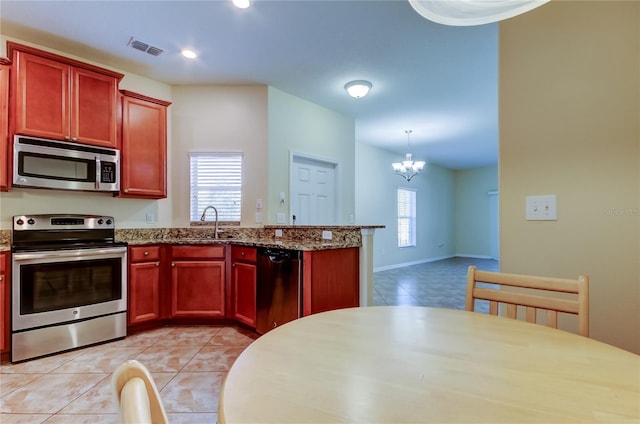 kitchen featuring an inviting chandelier, pendant lighting, light tile patterned floors, and appliances with stainless steel finishes