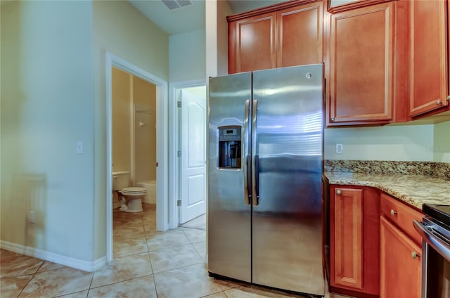 kitchen featuring light stone counters, light tile patterned floors, and appliances with stainless steel finishes