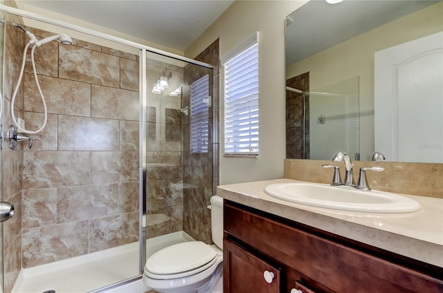 bathroom featuring walk in shower, vanity, and toilet