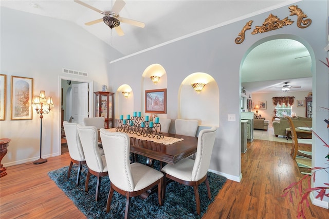 dining area with ceiling fan, wood-type flooring, and vaulted ceiling