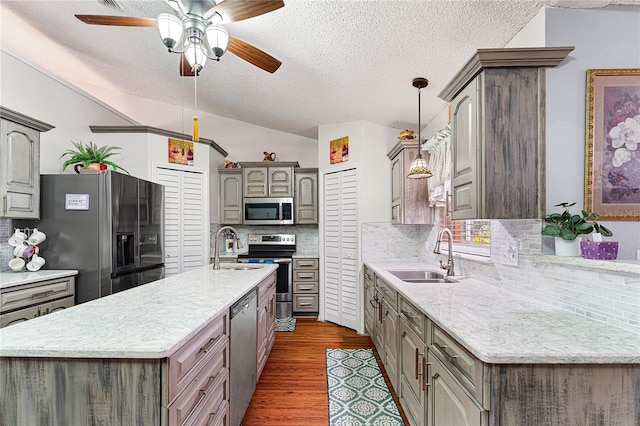 kitchen with sink, dark wood-type flooring, tasteful backsplash, lofted ceiling, and appliances with stainless steel finishes