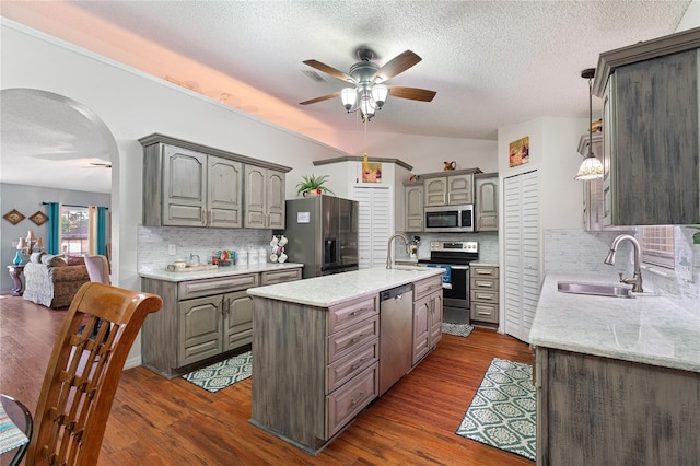 kitchen with dark hardwood / wood-style floors, a center island, sink, and appliances with stainless steel finishes