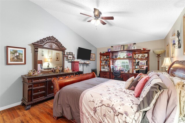 bedroom with ceiling fan, light wood-type flooring, a textured ceiling, and vaulted ceiling