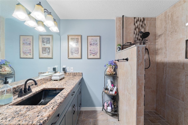 bathroom featuring tiled shower, vanity, and a textured ceiling