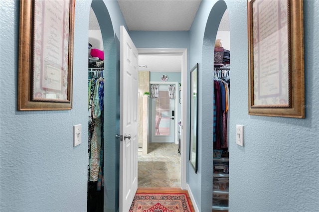 corridor with hardwood / wood-style floors and a textured ceiling