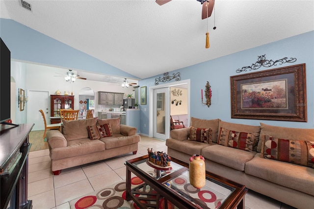 living room featuring a textured ceiling, light tile patterned flooring, and vaulted ceiling