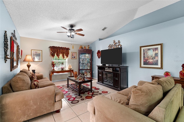 living room with ceiling fan, lofted ceiling, a textured ceiling, and light tile patterned floors