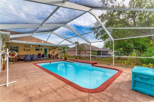 view of pool with ceiling fan, a patio area, an outdoor living space, and glass enclosure