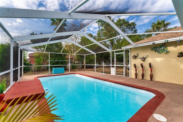 view of swimming pool featuring glass enclosure and a patio area