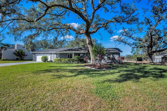 ranch-style house featuring a garage and a front lawn