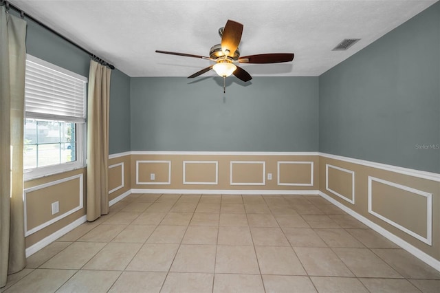 tiled spare room featuring ceiling fan and a textured ceiling