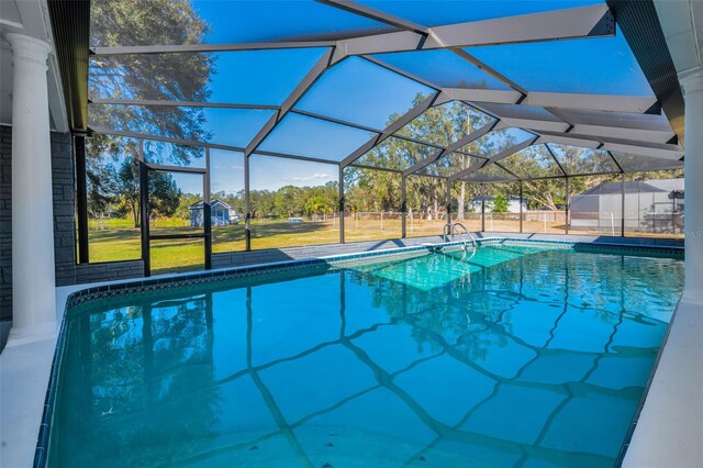 view of swimming pool featuring a lawn and glass enclosure