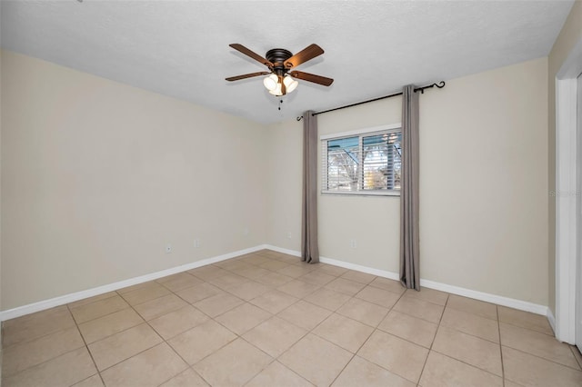 tiled empty room with ceiling fan and a textured ceiling