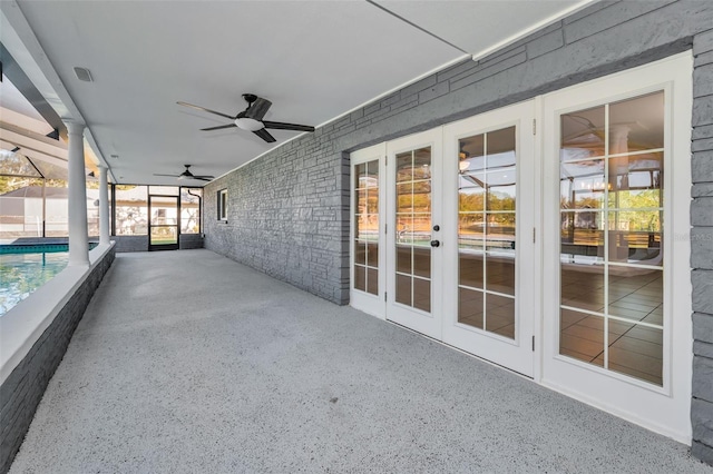 unfurnished sunroom featuring ceiling fan