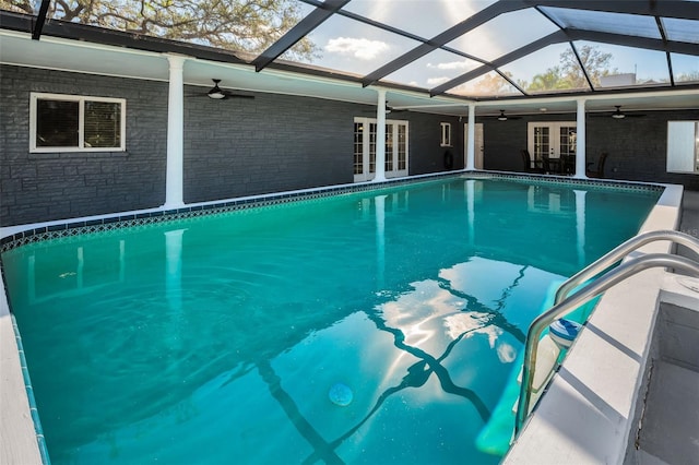 view of swimming pool with french doors and glass enclosure