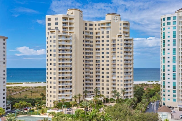 view of building exterior with a water view and a beach view