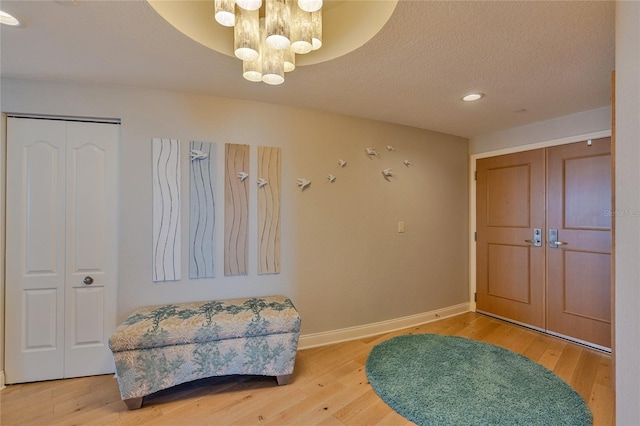 entrance foyer featuring a chandelier, a textured ceiling, and hardwood / wood-style flooring