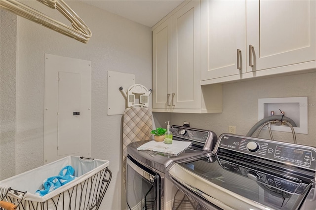 laundry room featuring washing machine and dryer, electric panel, and cabinets