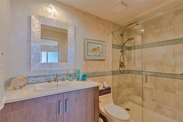 bathroom featuring vanity, an enclosed shower, and toilet