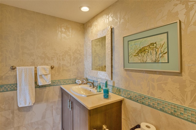 bathroom with vanity and tile walls