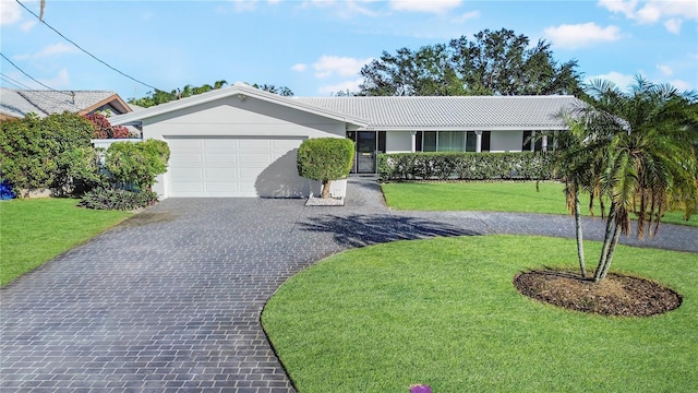 ranch-style home with a garage and a front lawn