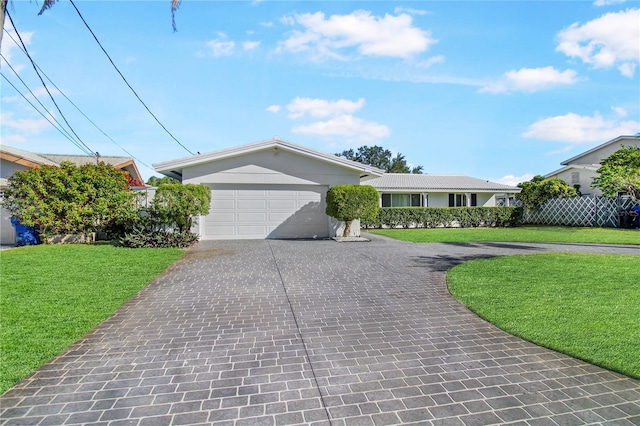 ranch-style house featuring a garage and a front lawn