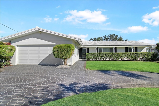 ranch-style home with a garage and a front lawn