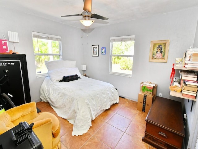 tiled bedroom featuring ceiling fan and multiple windows