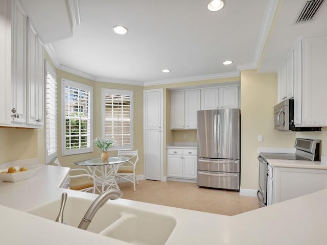 kitchen featuring white cabinets, appliances with stainless steel finishes, crown molding, and sink