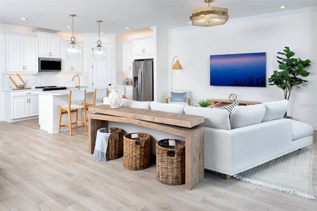 living room featuring light wood-type flooring and crown molding