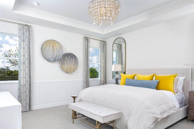 carpeted bedroom featuring a chandelier, a raised ceiling, and multiple windows