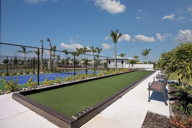 view of home's community featuring tennis court