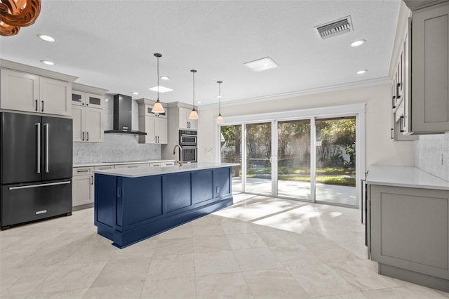 kitchen with a kitchen island with sink, hanging light fixtures, black electric cooktop, high end refrigerator, and wall chimney exhaust hood